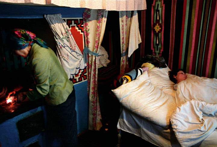 'The Price of Sex' Series, Photograph, 16 x 20 inches, (Olesea sleeps while her mom, Maria, prepares breakfast at six in the morning. During the winter months they share this one room to keep each other warm... Moldova 2004)