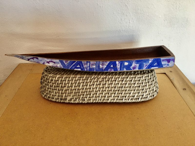 Traditional Handmade Wood Boat Sculpture. 'Vallarta' hand painted on exterior. Dark varnish stain interior. Measures 15.5 inches length x 3 inches width at back x 1.5 inches depth. Woven  Basket Base Not Included.. $100 pesos.