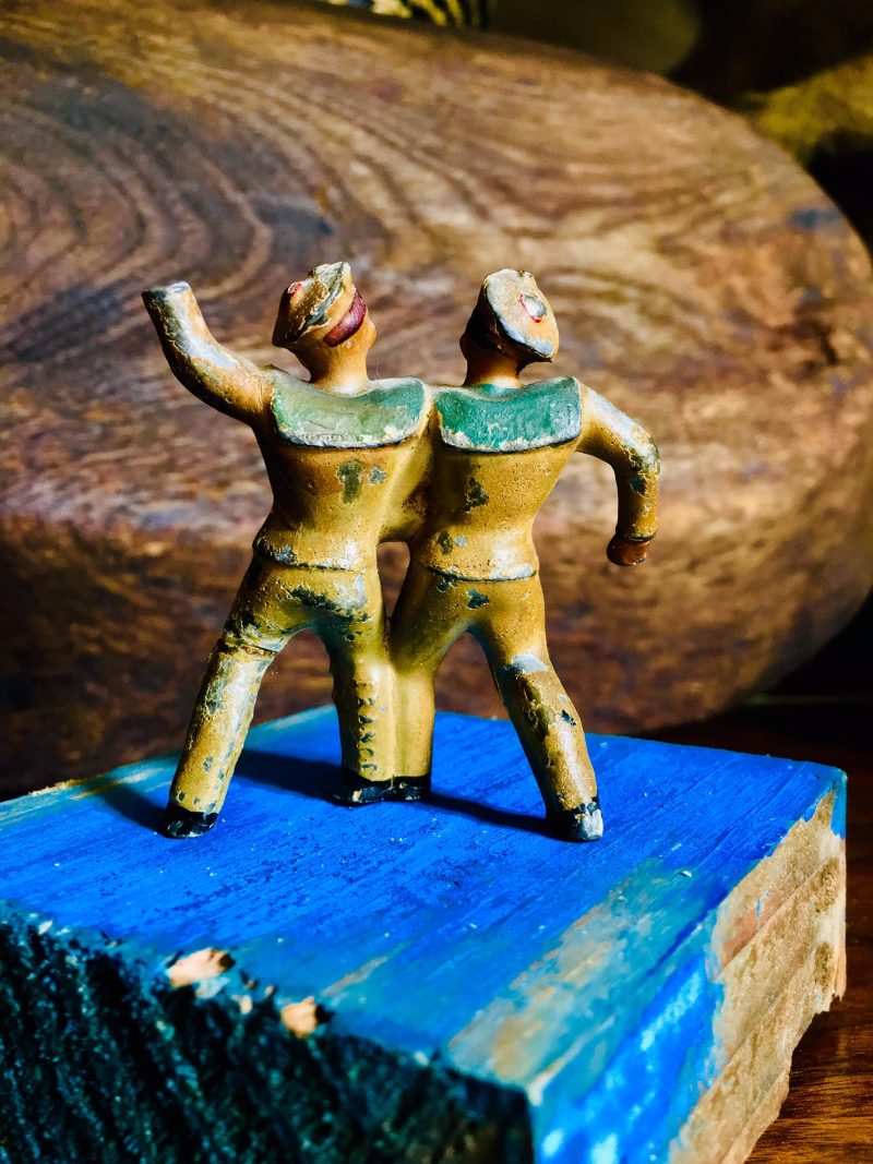 Antique Pair of 'Drunken' Sailors, or they are secretly lovers. Made of metal, 1920's. One leg seems to have been soldered or glued ages ago, perhaps from a drunken fall. $25. (verso)