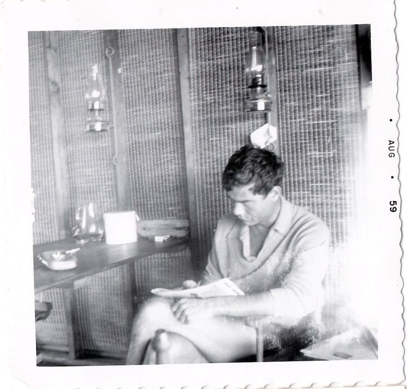 Mid Century Authentic Photograph, 'Young Man Reading the Paper at the Beach House', Measures 3.5 x 3.5 inches, Dated August 1959, SOLD.