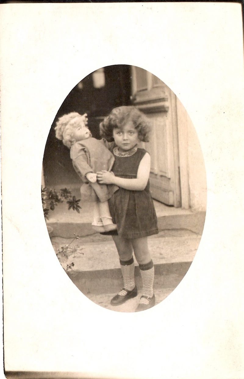 Vintage Authentic Photograph/Postcard. 'Adorable Little Girl with Doll & Stripped Socks'. Handwritten on verso 'It's a sad Merry Christmas. David Protetch. 1962'. (New York). Measures 3.5 x 5.5 inches. From an American Estate Sale. $25.