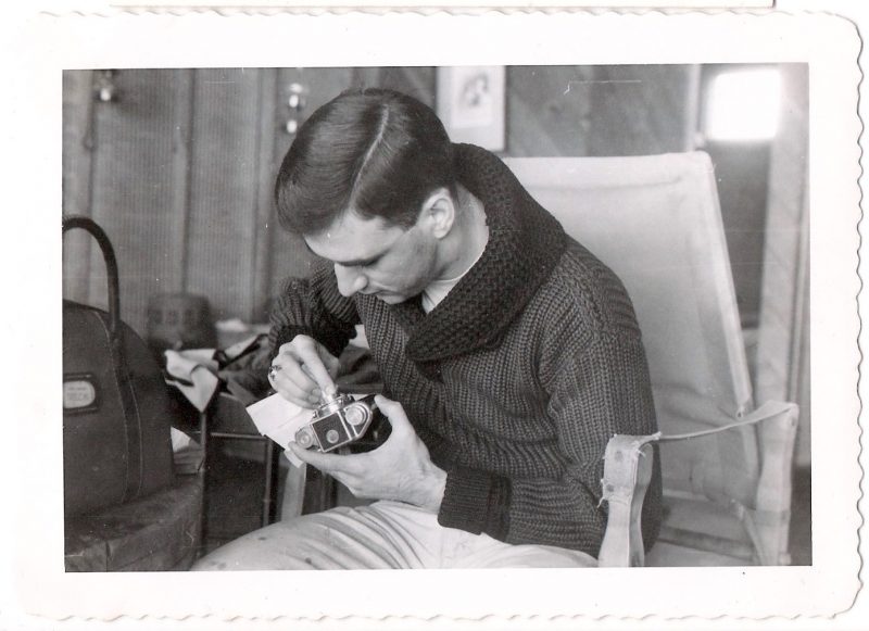 Mid Century Vintage Authentic Photograph, 'Man with Fab Hairdo Cleaning his Camera', Handwritten on verso '1957'. Measures 4.5 x 3.25 inches. From an American estate sale. SOLD.