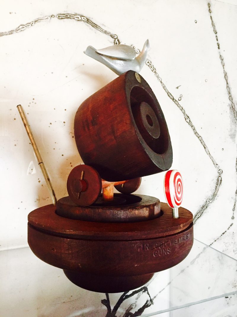 “Good Ship Lollipop” aka “In God (crossed out) Guns We Trust” 1972, Arthur ‘Art’ Price, Found Wood Antique Hat Forms & Bird Sculpture in Aluminum & Polychrome (made by the artist), Found American Dime 1960’s, Spiral Wood Lollipop sculpture (made by the artist), 17 height x 10.5 width x 17 depth (with metal rod) inches. One of a kind sculpture. Titles & artist named stamped / see original photos from 1970’s catalogue of the artist’s artworks entitled “Art Price. Happiness Is Where You Find It. Volume 2”.