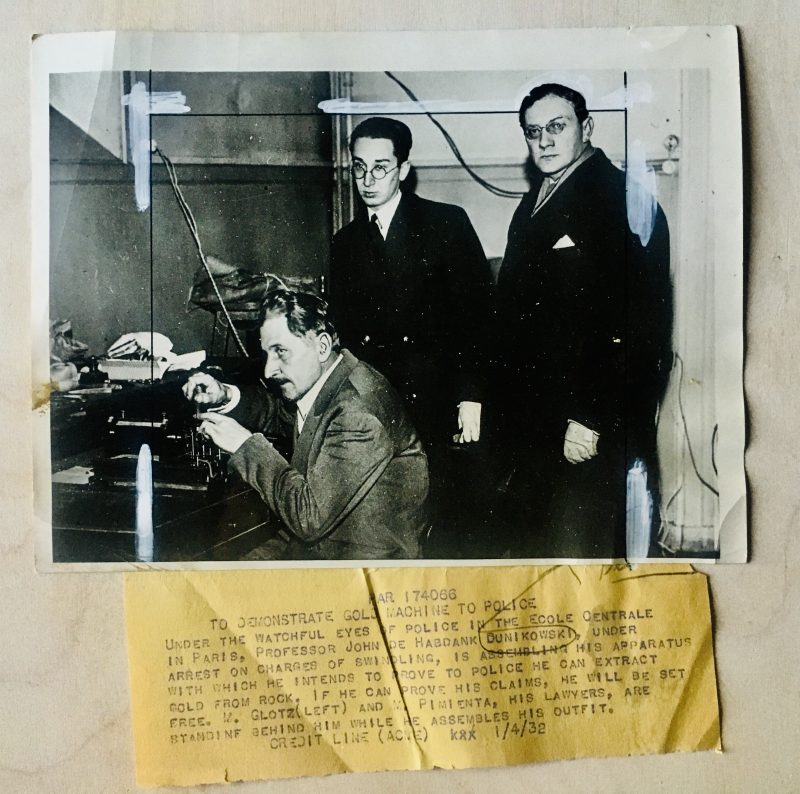 Authentic Vintage Photograph with ink and white paint crop marks meant for press/publishing. Measures 8 x 6 inches. Credit ink stamp on verso;'Photo by Acme NewsPictures, Inc., New York City. News paper clipping attached says; 'To Demonstrate Gold Machine to Police. Under the watchful eye of the police in the Ecole Centrale in Paris, Professor John de Habdank Dunikowski, under arrest on the charges of swindling, is assembling his apparatus with which he intends to prove police he can extract gold from rock... (more text). USD$35.